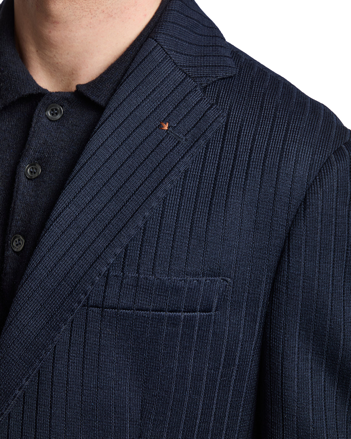 Navy striped blazer in soft fabric, paired with a textured dark polo collar for a sophisticated casual look.