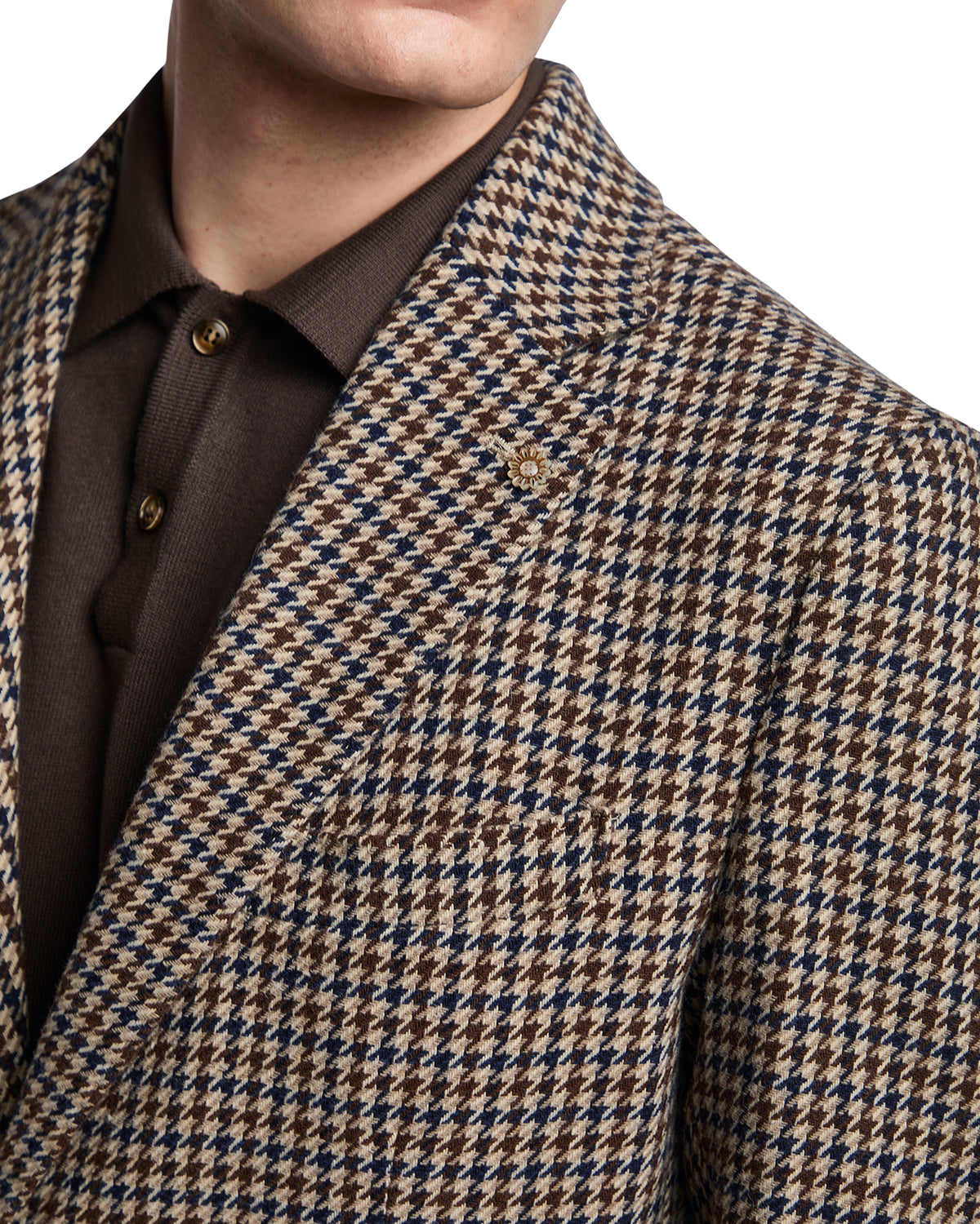 Brown and blue houndstooth blazer with a tailored fit, styled over a knitted brown polo shirt.