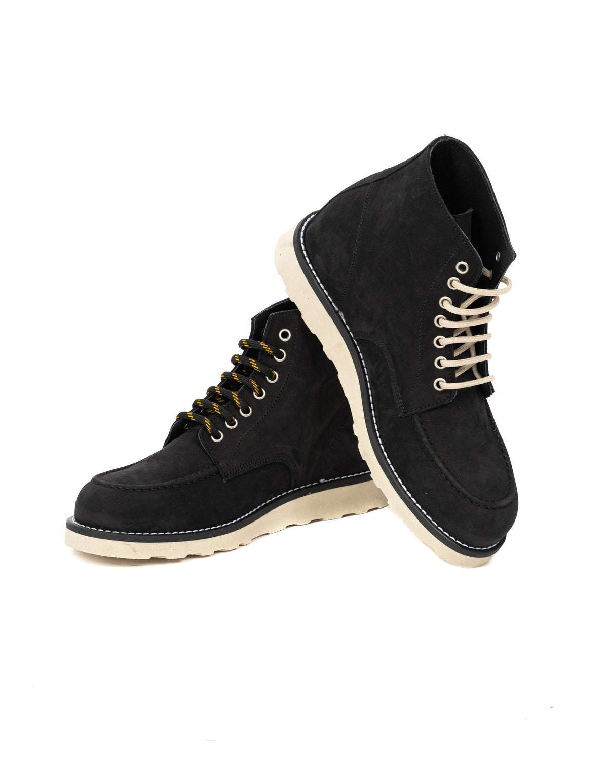 Black suede moc-toe work boots with cream laces, off-white rubber sole, and yellow accent laces.