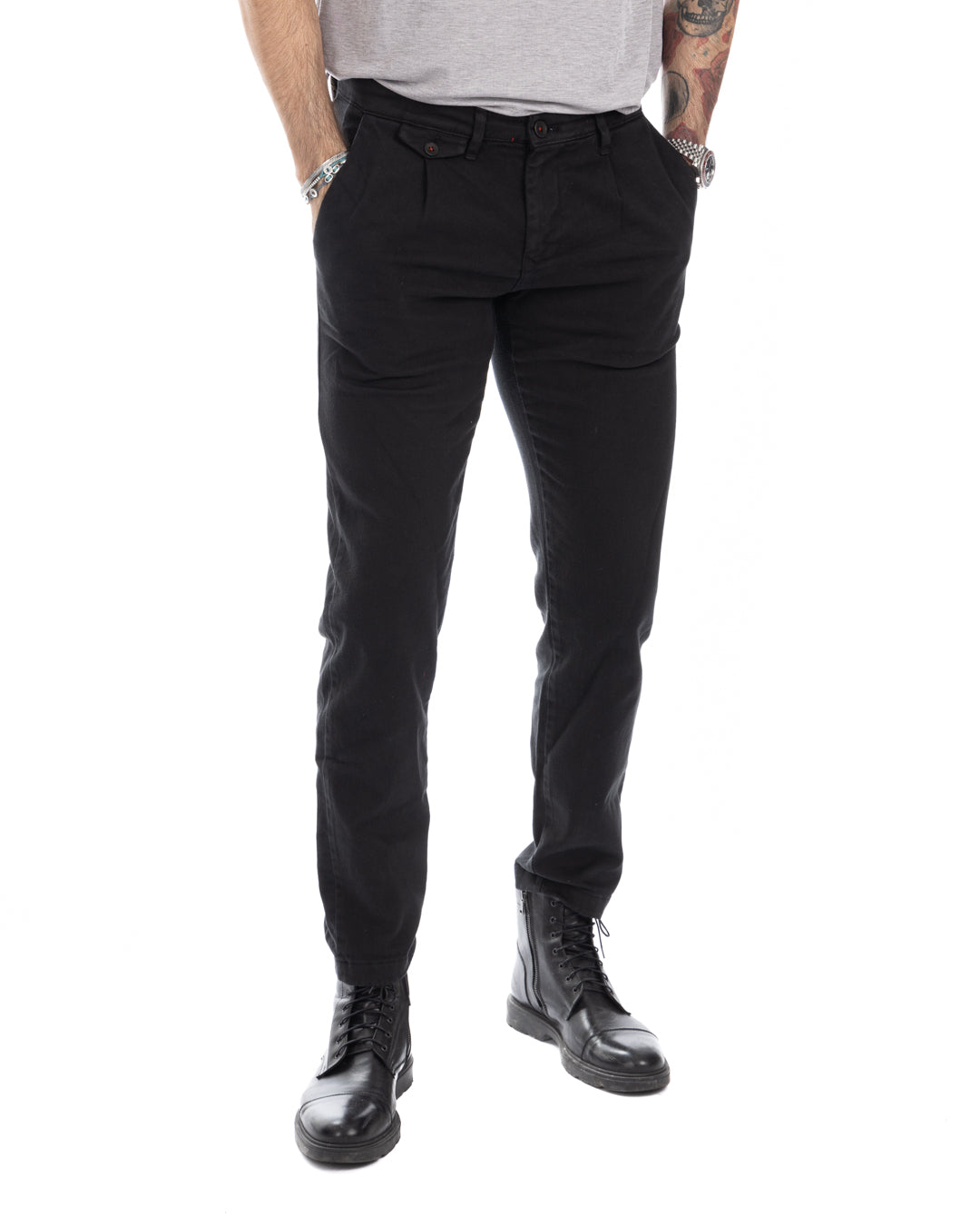 Black slim-fit cotton chinos with pleated front, worn with black leather combat boots.