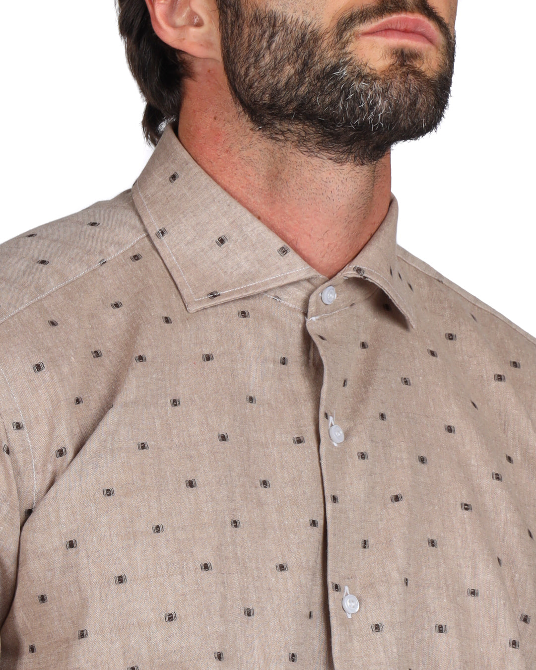 Close-up of the collar of a beige linen shirt with brown dot pattern
